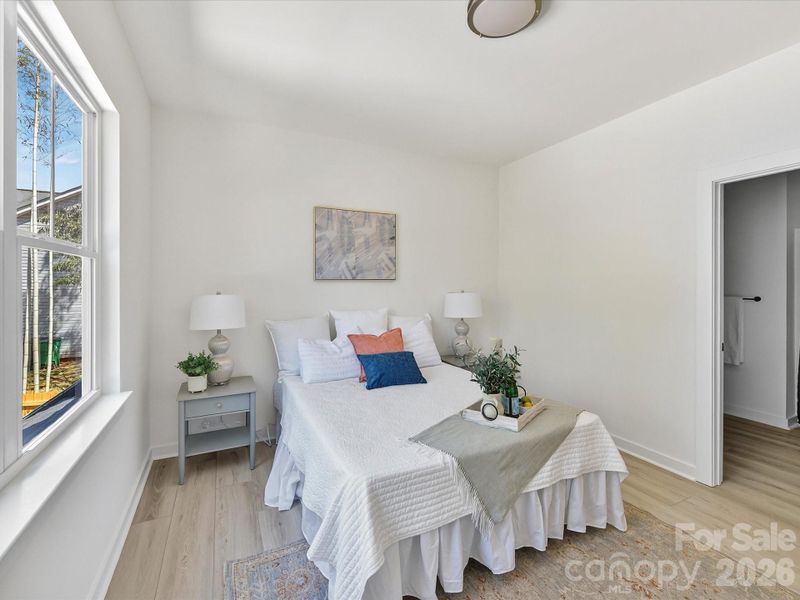 Spacious and light-filled primary suite featuring large windows, neutral finishes, and a comfortable layout perfect for rest and relaxation. Spacious and light-filled primary suite featuring large windows, neutral finishes, and a comfortable layout perfect for rest and relaxation.