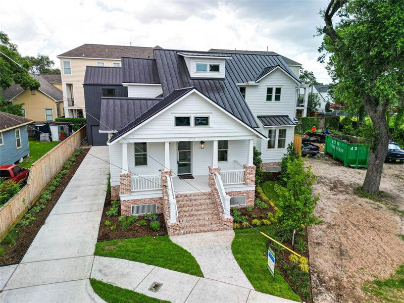 A two-story home with a white exterior, surrounded by a security system with motion detectors and cameras, nestled in a residential neighborhood.