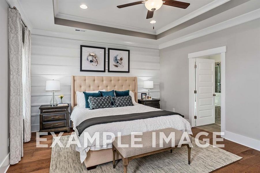 Bedroom with dark hardwood / wood-style flooring, a raised ceiling, ceiling fan, and crown molding