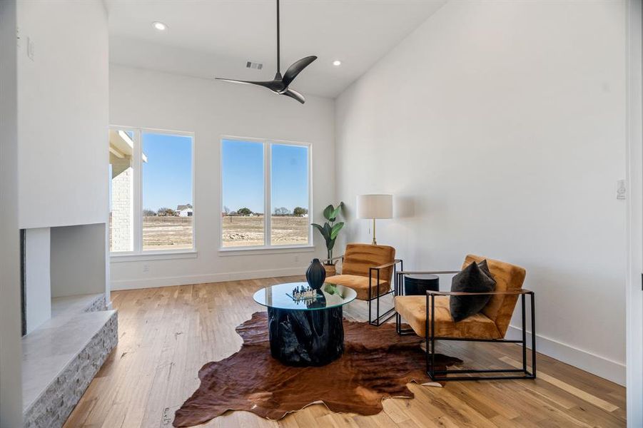 Living area with ceiling fan and light hardwood / wood-style floors