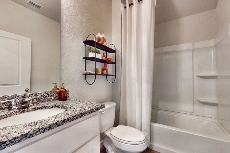 A bathroom with a sink toilet and shower.