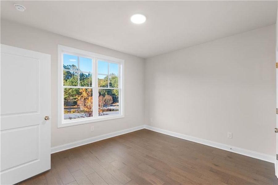 Spare room with baseboards and dark wood finished floors