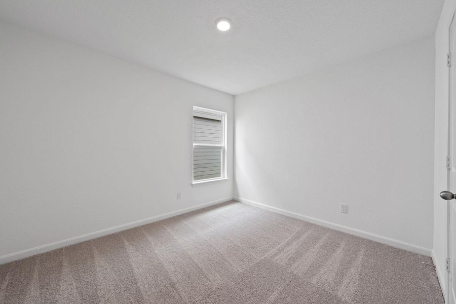 Empty room featuring light colored carpet and baseboards