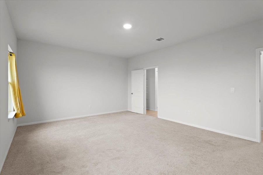 Spacious room featuring neutral carpet, white baseboards, and light gray painted walls