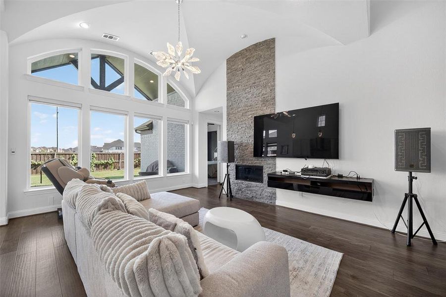 Living area with a chandelier, high vaulted ceiling, and dark wood-style flooring Living area with a chandelier, high vaulted ceiling, and dark wood-style flooring