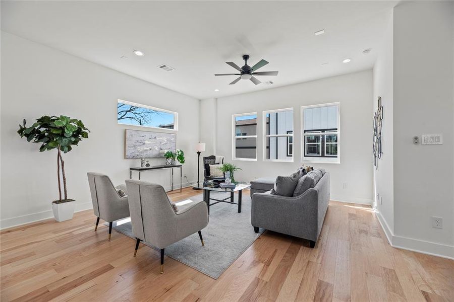 The living room is bathed in light from the windows.  There’s lots of space to spread out.