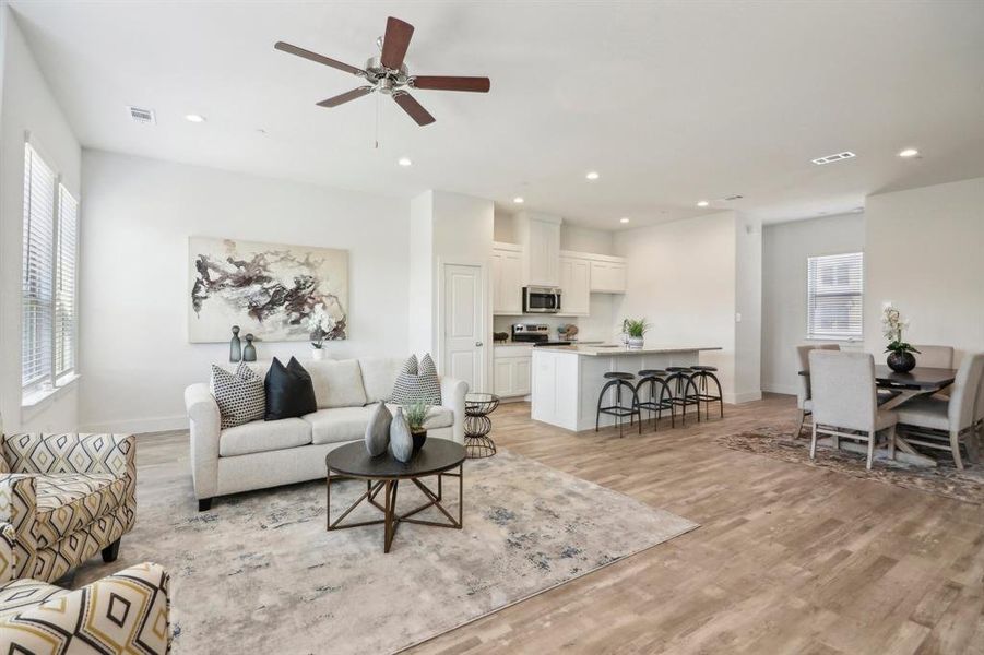 Living room with light hardwood / wood-style floors and ceiling fan