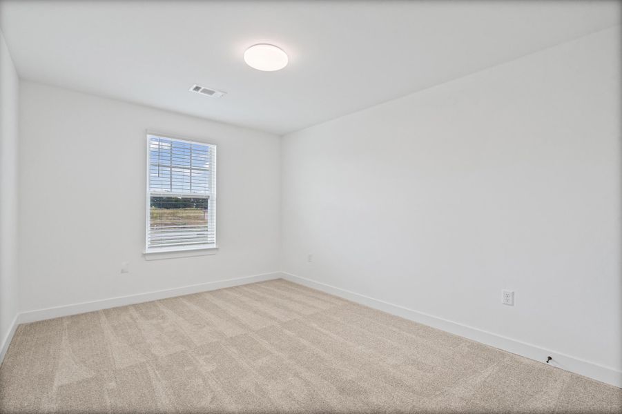 Recessed ceiling light fixture, white walls, carpeted flooring, and a single window with blinds