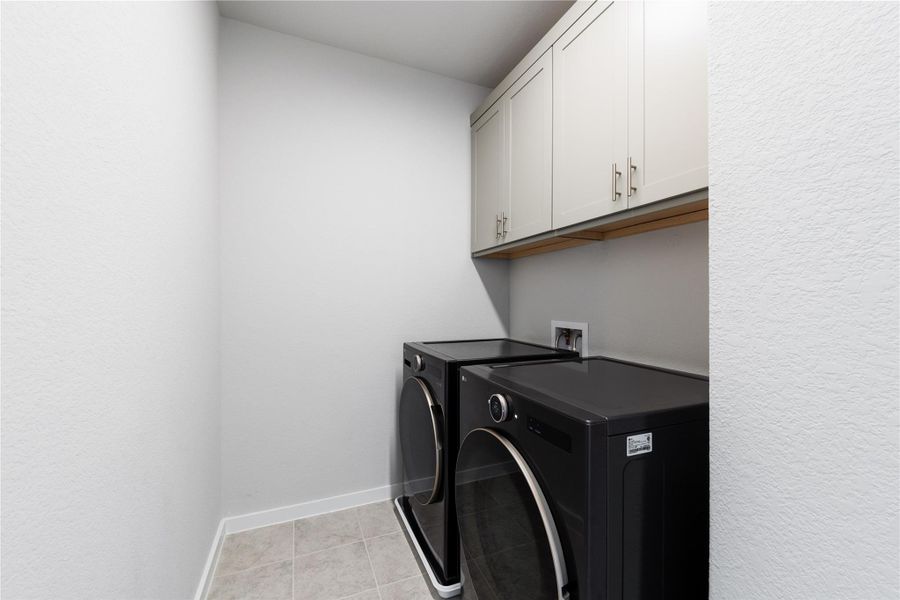 Laundry room with baseboards, cabinet space, independent washer and dryer, and light tile patterned floors