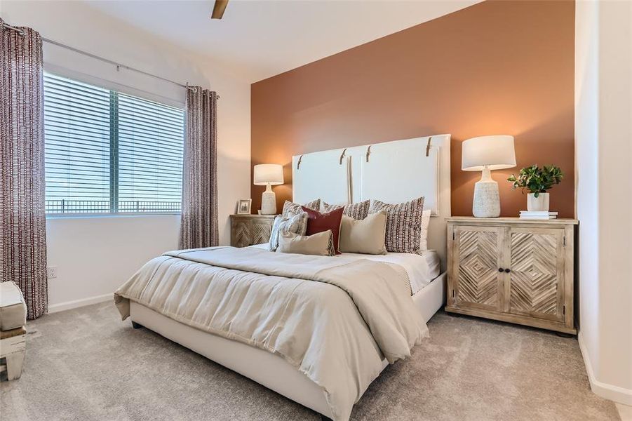 Carpeted bedroom featuring baseboards and ceiling fan