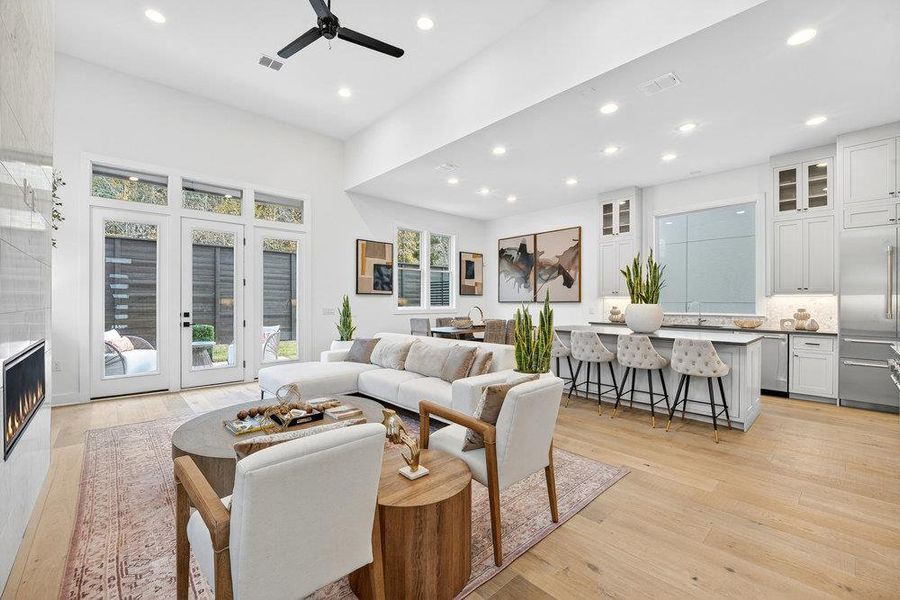 Living area with light wood-type flooring, recessed lighting, ceiling fan, healthy amount of natural light, and french doors