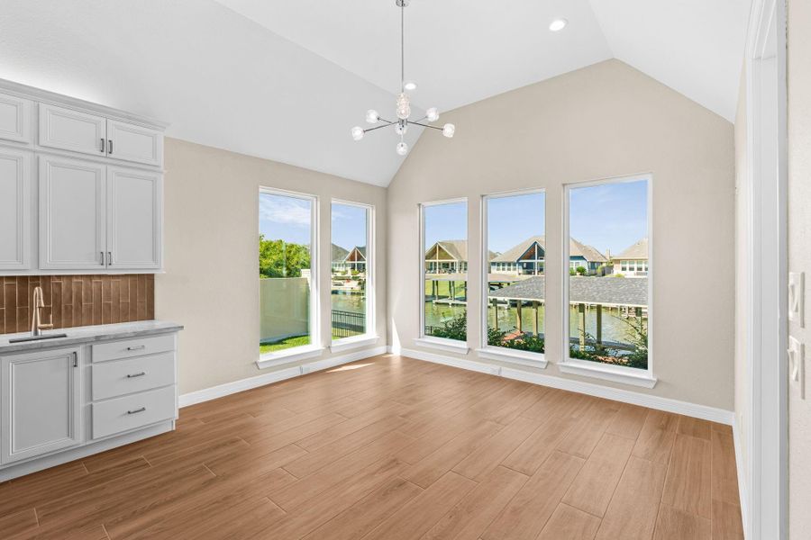 Light-filled dining nook surrounded by windows offering scenic views and an airy, welcoming space for meals.
