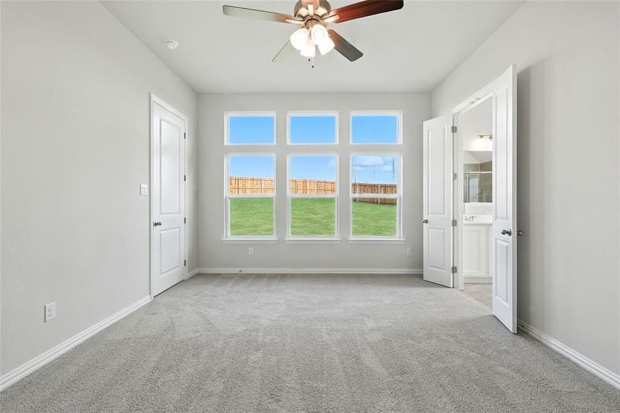 Carpeted spare room featuring ceiling fan and baseboards Carpeted spare room featuring ceiling fan and baseboards