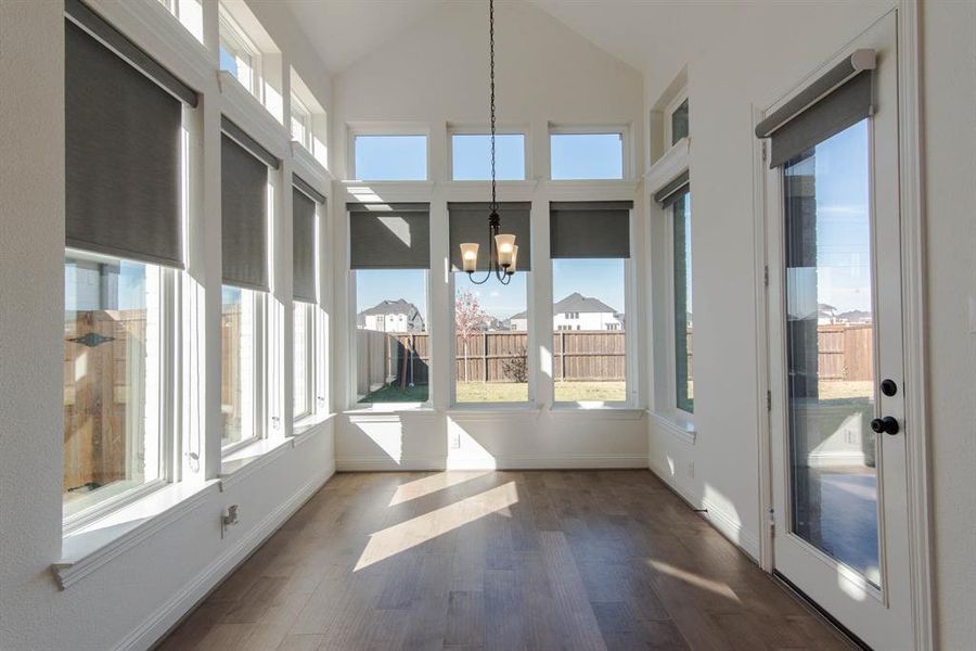 sunroom with a chandelier and vaulted ceiling