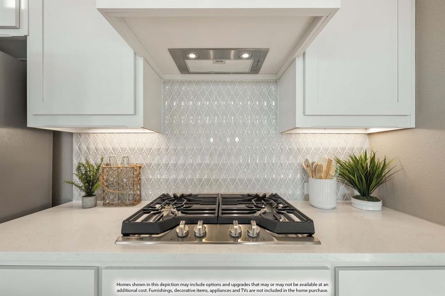 Kitchen cooktop area with white cabinets, diamond tile backsplash, and stainless steel gas range with built-in hood