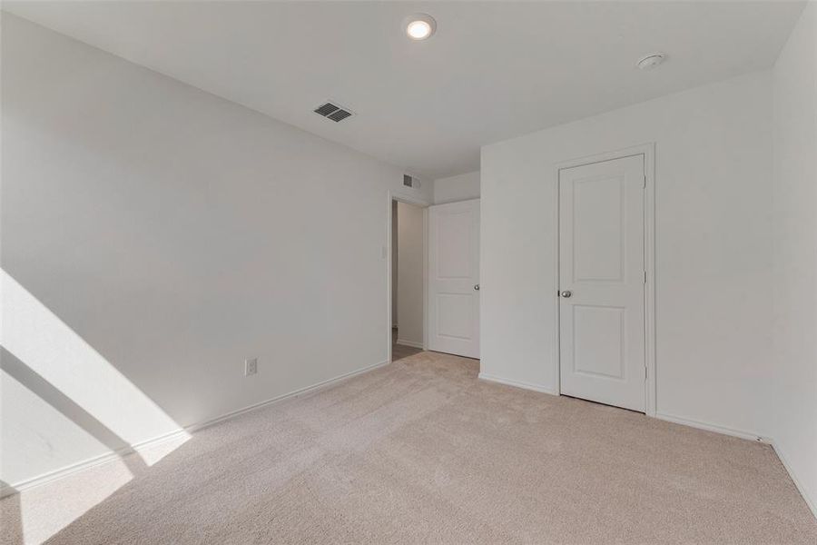 Unfurnished bedroom featuring light colored carpet