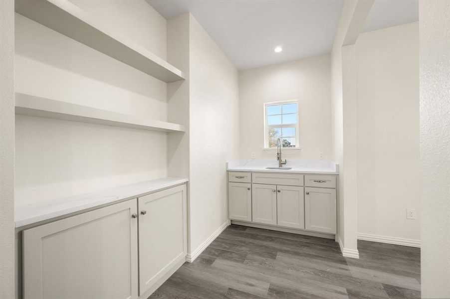 Bar with open shelves, dark wood-style flooring, white cabinetry, light stone counters, and recessed lighting Bar with open shelves, dark wood-style flooring, white cabinetry, light stone counters, and recessed lighting