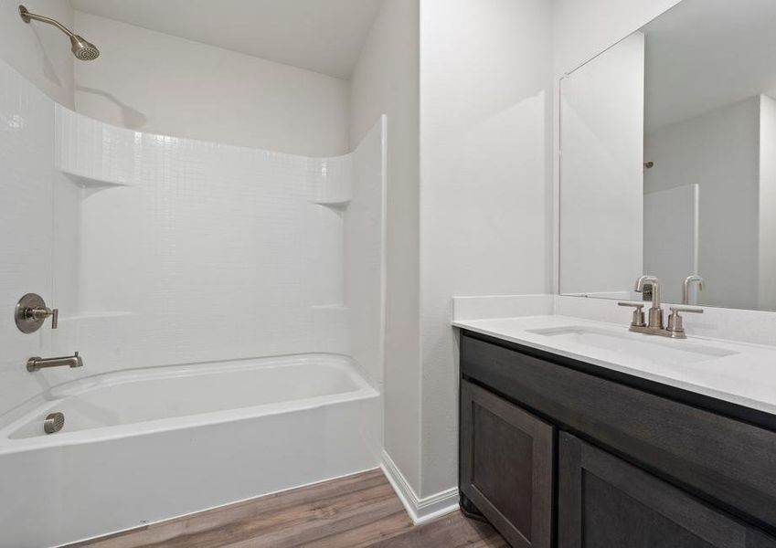 The master bathroom has a spacious vanity space and a shower-tub combo.