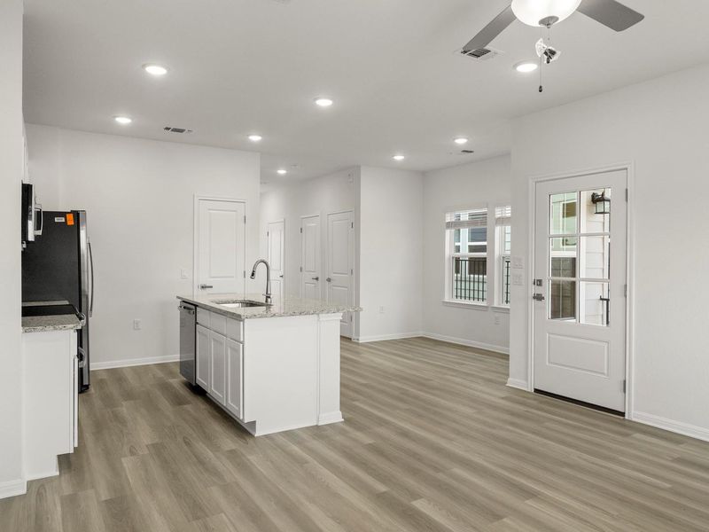 An open concept kitchen and living area with contemporary finishes and abundant natural illumination.
