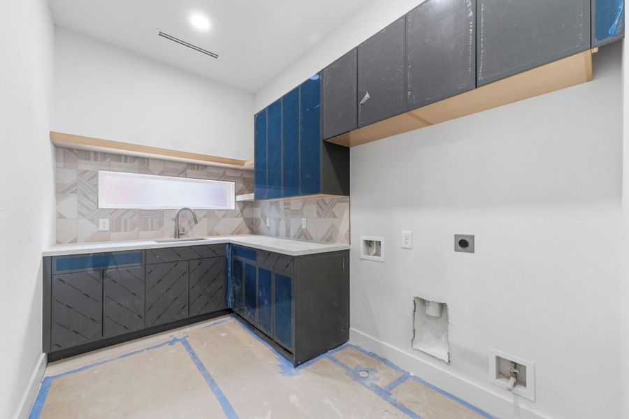 A full-sized laundry room on the second floor features abundant storage and an artistic tile layout. A full-sized laundry room on the second floor features abundant storage and an artistic tile layout.