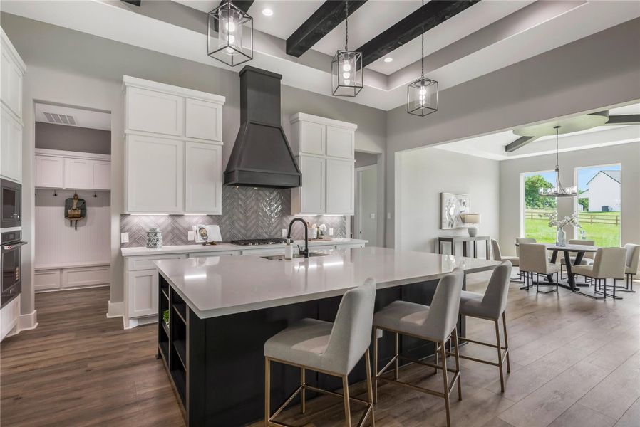 Modern kitchen with a spacious island, sleek white cabinetry, and a stylish range hood. Modern kitchen with a spacious island, sleek white cabinetry, and a stylish range hood.
