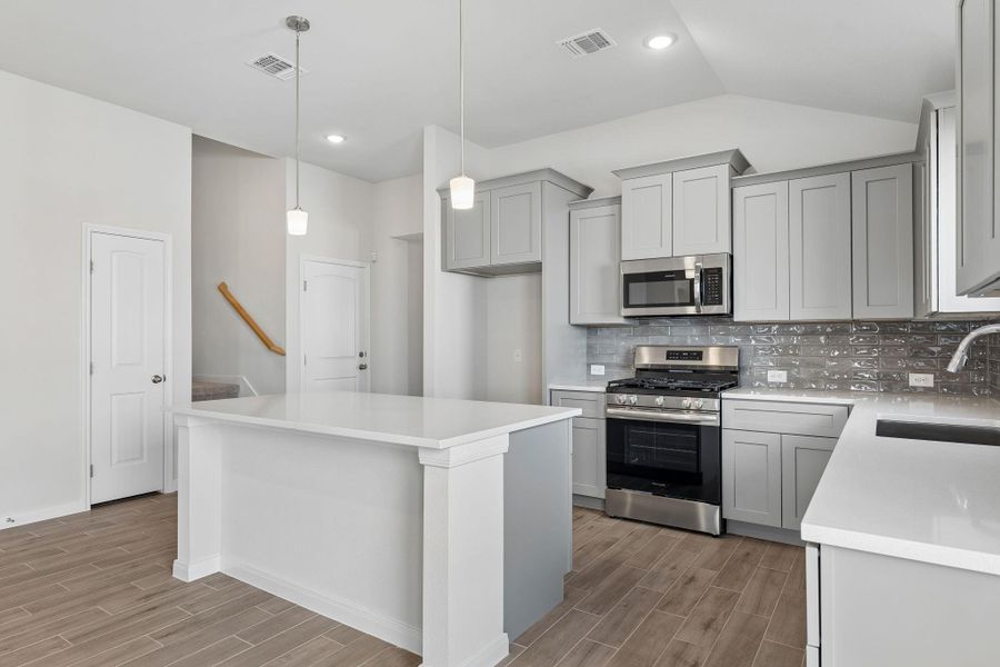 Modern cabinetry and granite countertops define this light-filled culinary workspace.