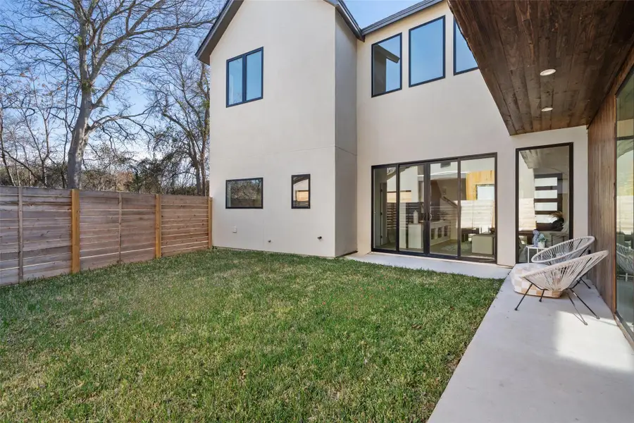 Rear view of house with a yard and a patio