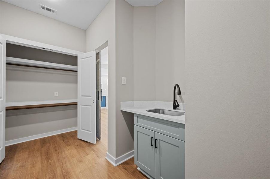 Large utility/laundry room with sink and additional panty/storage.