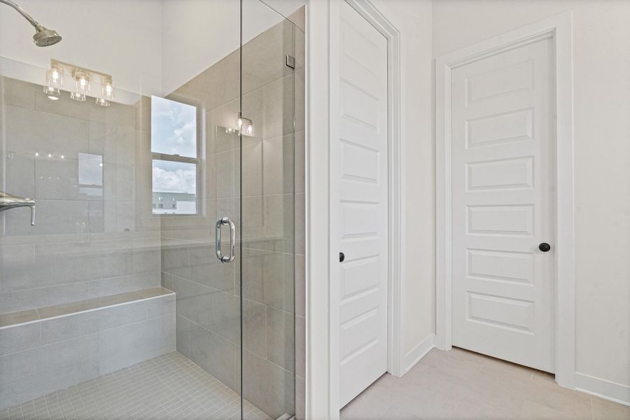 Walk-in shower with full glass enclosure, tiled walls, built-in bench, and rain showerhead Walk-in shower with full glass enclosure, tiled walls, built-in bench, and rain showerhead