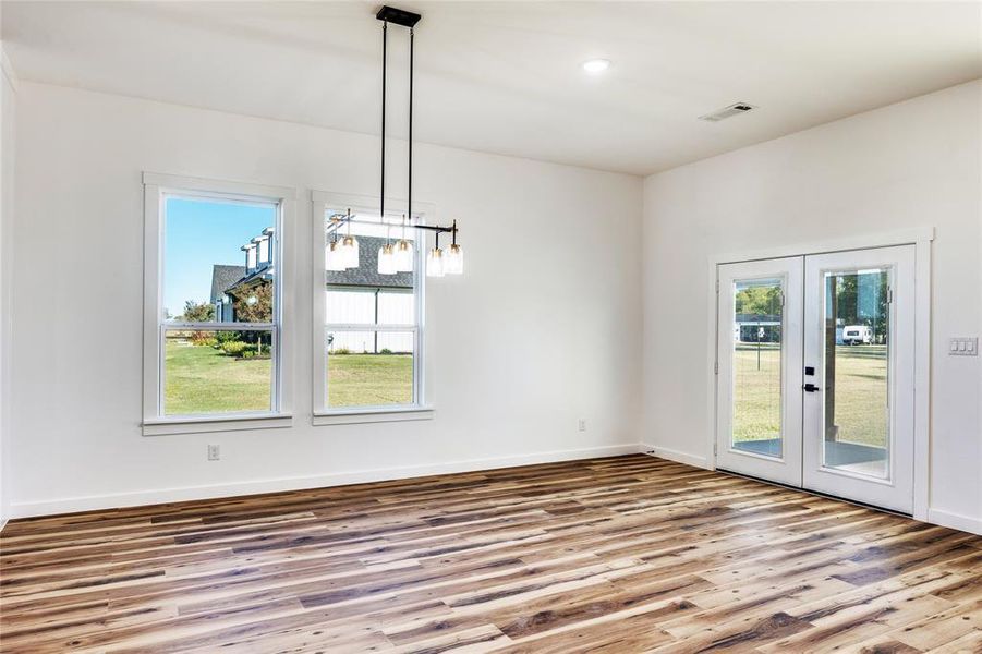 Unfurnished dining area with french doors, wood finished floors, and recessed lighting