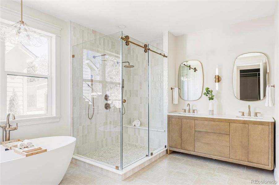 Spa-inspired primary bath with soaking tub, double vanity, and oversized shower