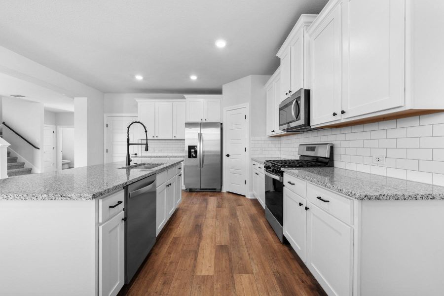 A well-appointed kitchen features sleek stainless steel appliances, pristine white cabinetry, and gleaming granite countertops. A well-appointed kitchen features sleek stainless steel appliances, pristine white cabinetry, and gleaming granite countertops.