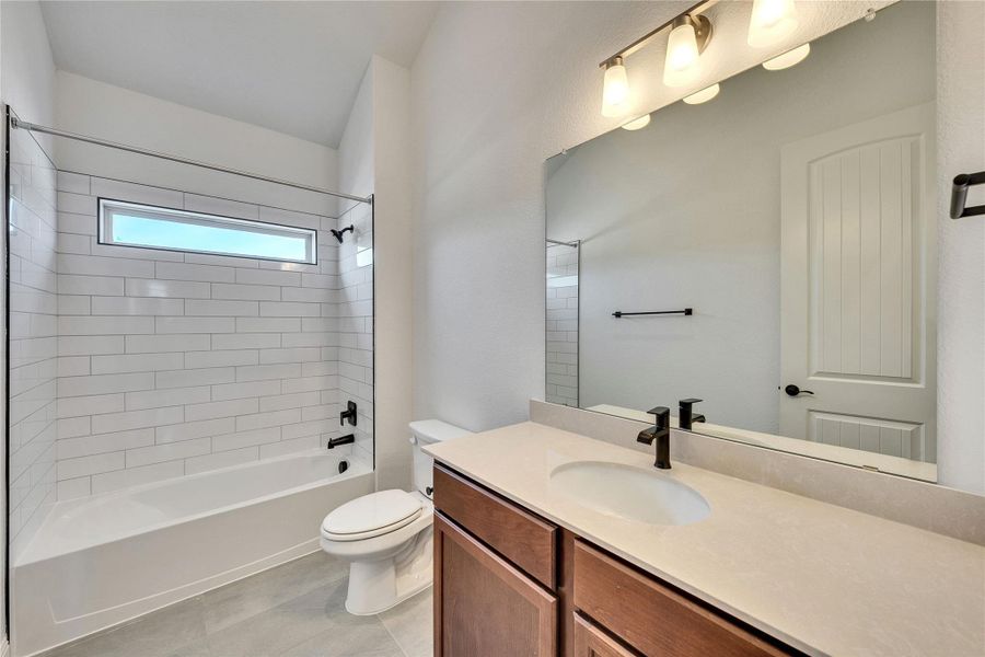 Bathroom featuring bathtub / shower combination, vanity, and light tile patterned floors Bathroom featuring bathtub / shower combination, vanity, and light tile patterned floors