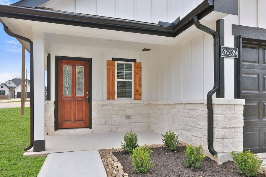 Imagine time on the front porch surrounded by white siding and stone accents. Neatly landscaped with small shrubs, this porch offers great curb appeal.