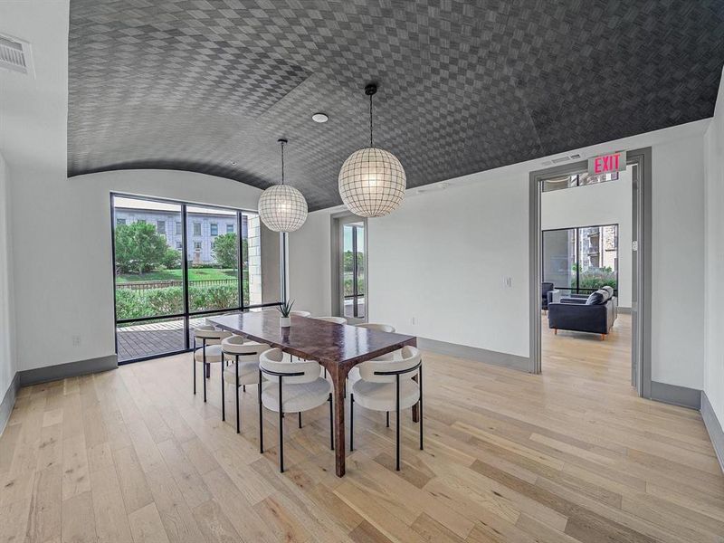 Dining room featuring light wood finished floors, healthy amount of natural light, and lofted ceiling