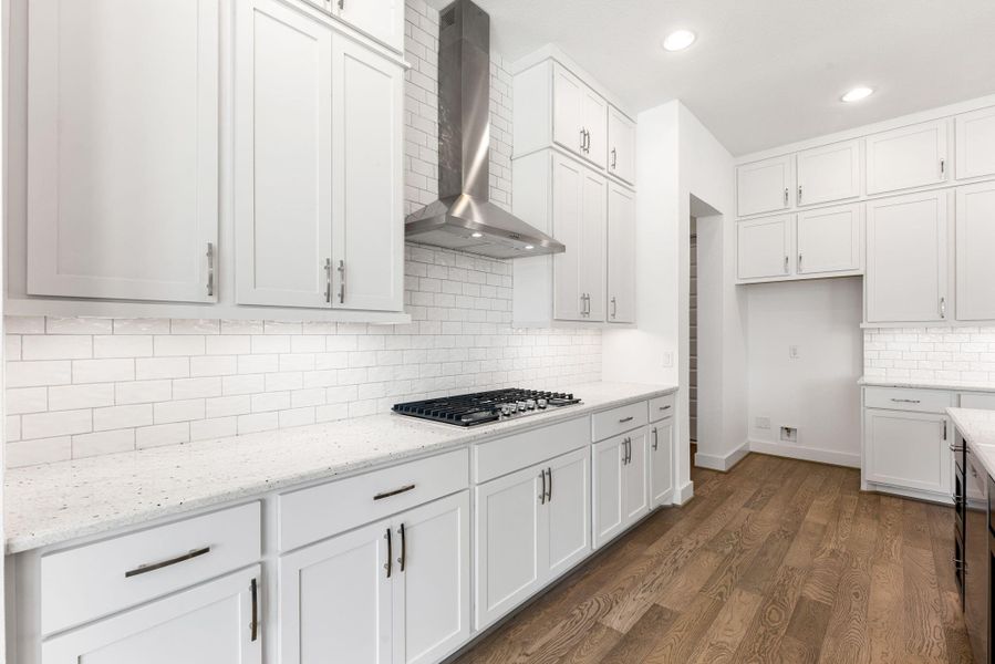 Island kitchen with tons of storage space, stainless steel appliances, tile backsplash and a 5-burner gas stove stop