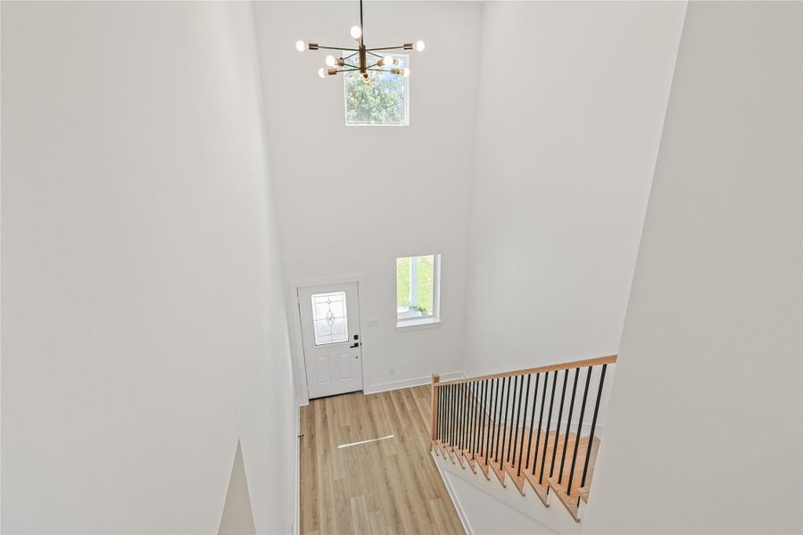 Experience the awe-inspiring view of the grand foyer from the second floor, where soaring ceilings and abundant natural light create a bright, open, and elegant atmosphere. This striking architectural feature sets the tone for the entire home, welcoming you with timeless beauty and spaciousness.