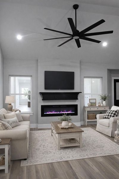 Living area with a glass covered fireplace, recessed lighting, light wood-style flooring, and ceiling fan