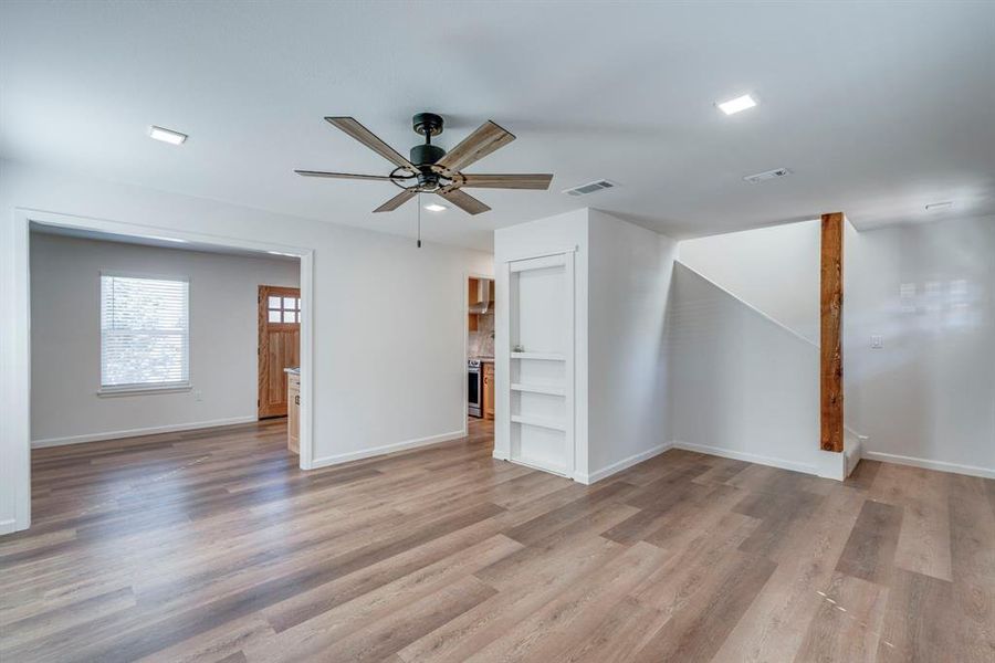 Additional living space with light hardwood / wood-style flooring and ceiling fan