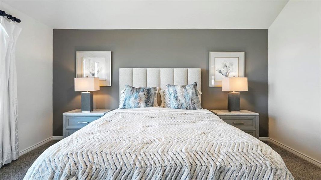 Bedroom featuring dark carpet and baseboards