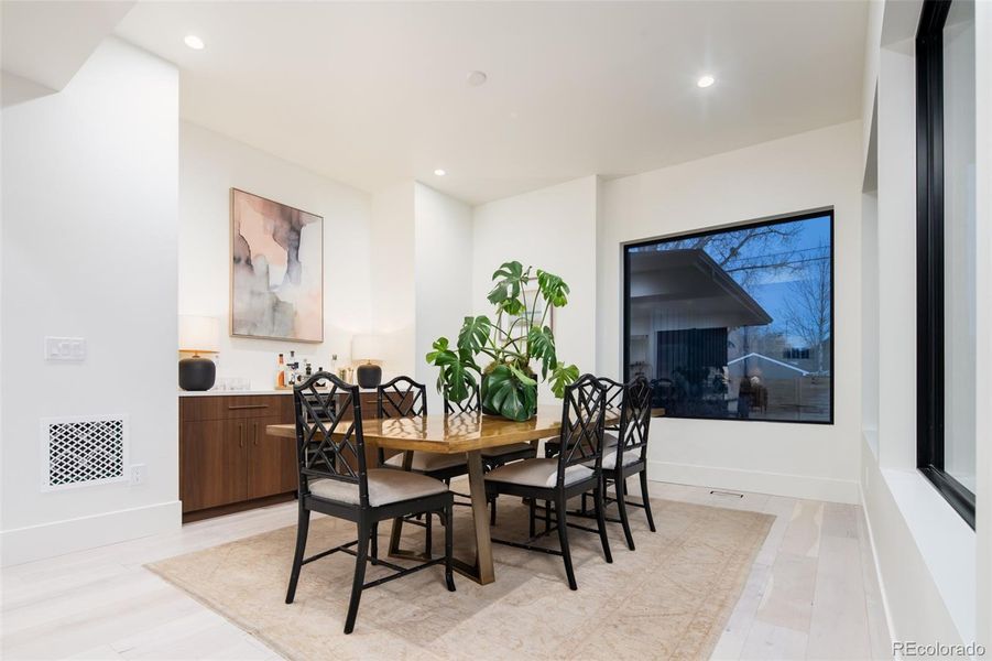 Dining room with large dry bar including wine fridge and 3 large 6'x6' windows overlooking the backyard