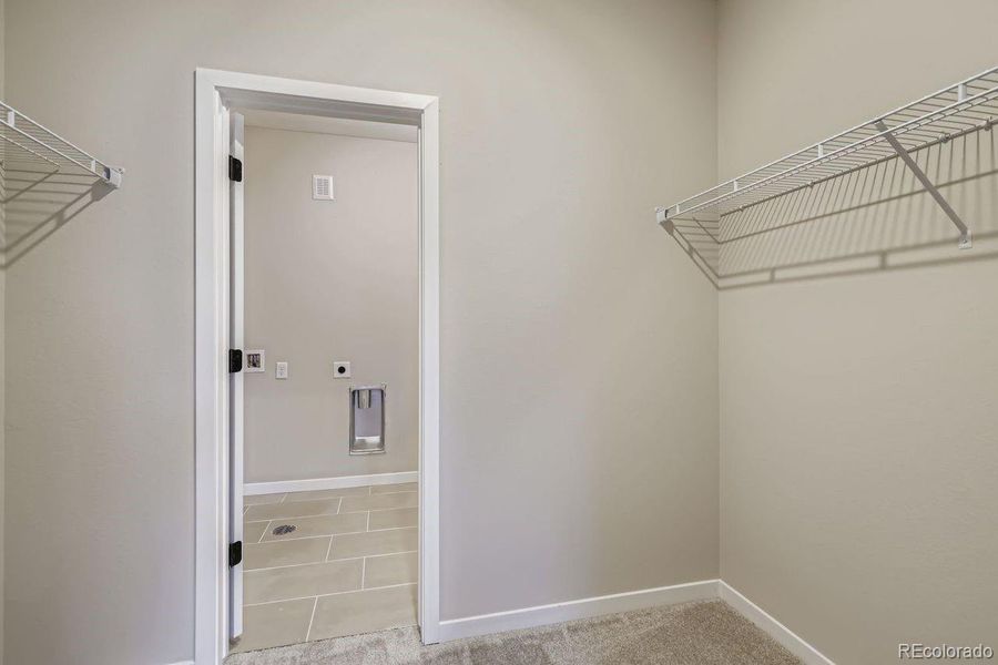Primary Walk-In Closet with direct passage to laundry