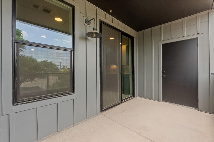 Entrance to property featuring board and batten siding and a patio area