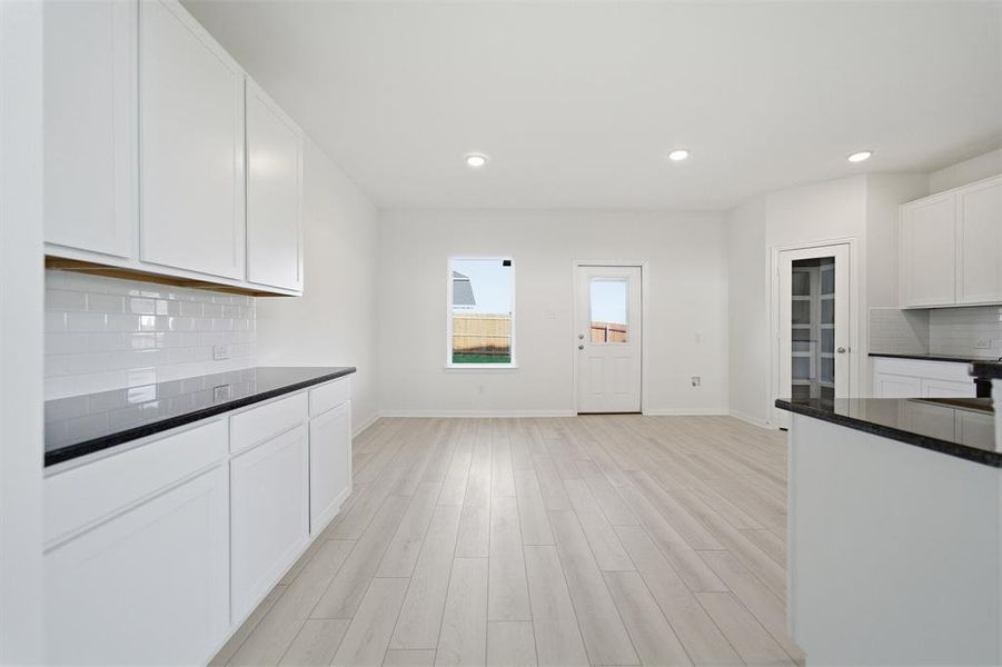 Spacious open-concept living area featuring light wood-finish flooring