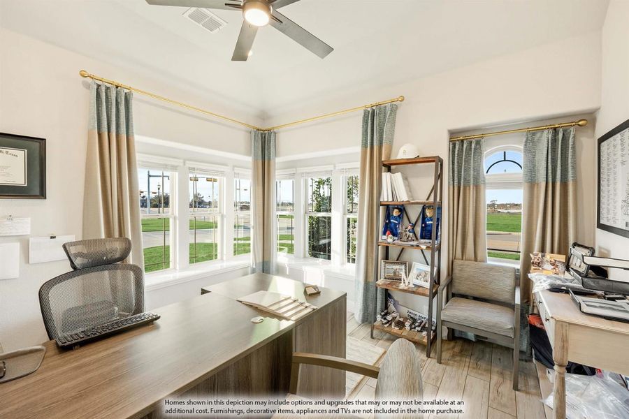 Home office with wood desk, ceiling fan, large windows, and open shelving unit Home office with wood desk, ceiling fan, large windows, and open shelving unit