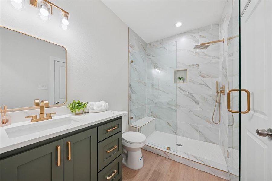 Full bath featuring a marble finish shower, vanity, light wood-style floors, and recessed lighting Full bath featuring a marble finish shower, vanity, light wood-style floors, and recessed lighting
