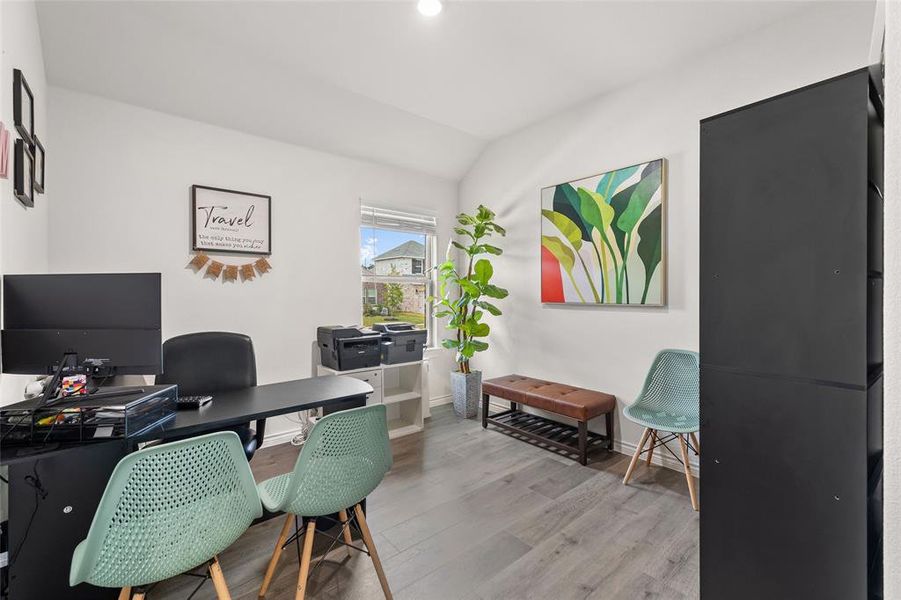 Office area featuring light wood-style floors and vaulted ceiling Office area featuring light wood-style floors and vaulted ceiling
