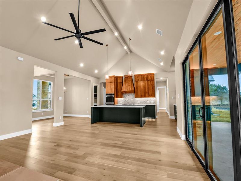 Kitchen with a large island, ceiling fan, oven, pendant lighting, and a breakfast bar