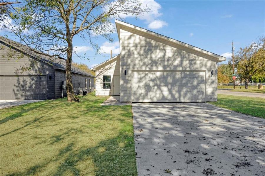 View of home's exterior featuring a yard and a garage