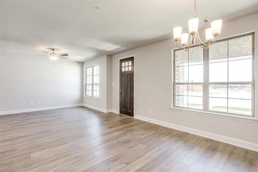 Unfurnished room with suspended lighting, light wood finished floors, and a ceiling fan